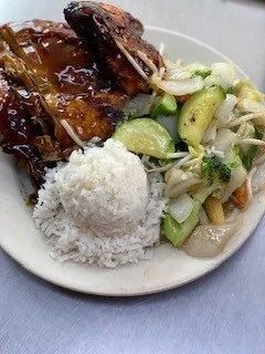Plate of glazed roasted meat with rice and sautéed vegetables on a white dish
