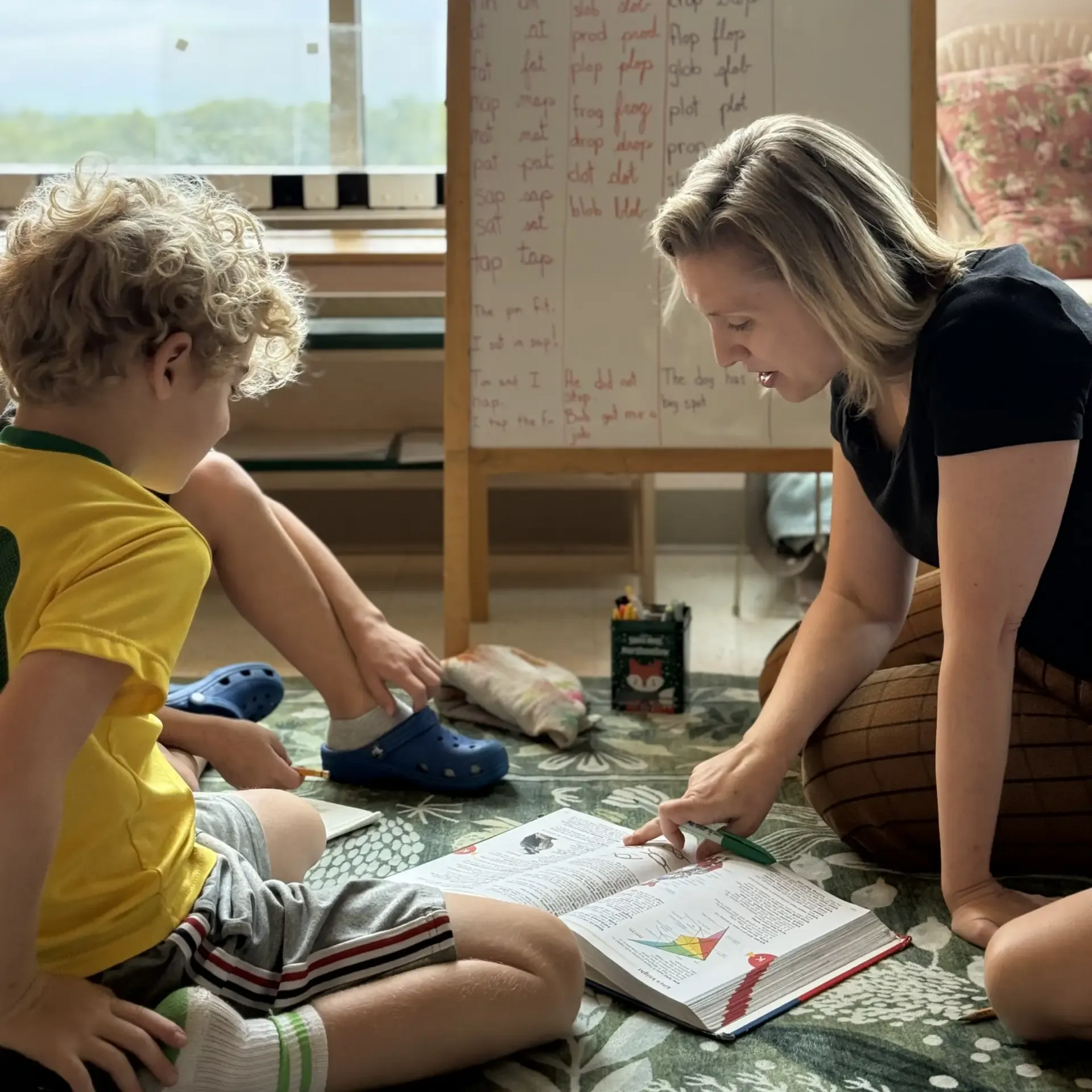 Montessori guide and children working in the classroom.