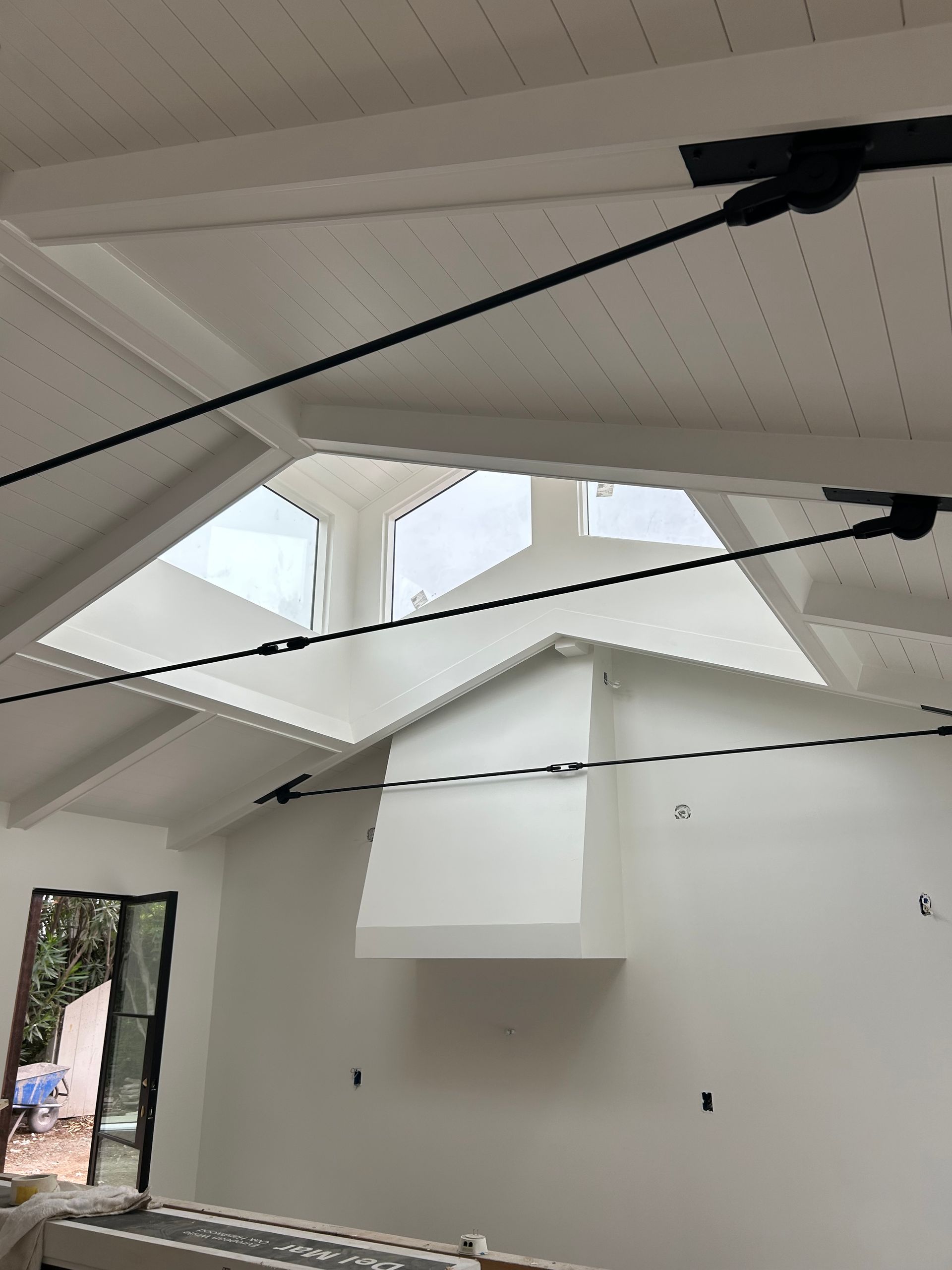 Interior with white walls, skylight, and black support beams.