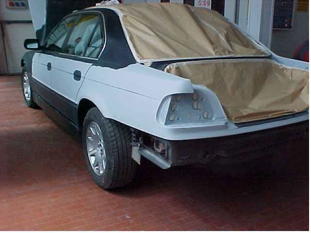 Un'auto in bianco e nero viene verniciata in un garage