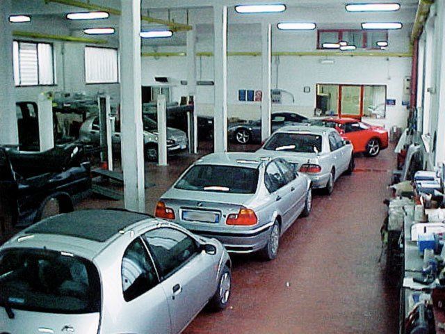 Una fila di auto color argento è parcheggiata in un garage