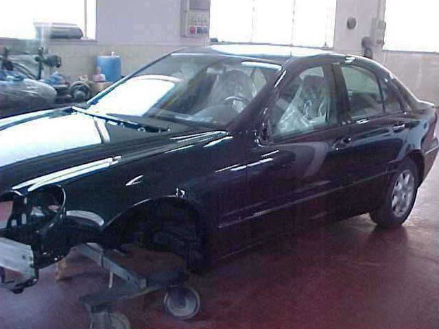 Un'auto nera è seduta su un carrello in un garage