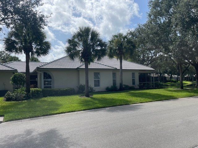A white house with a gray roof installed by Four Peaks Roofing in Punta Gorda