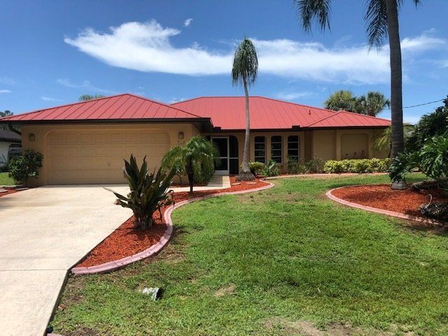 A house with a red roof by Four Peaks Roofing in Cape Coral