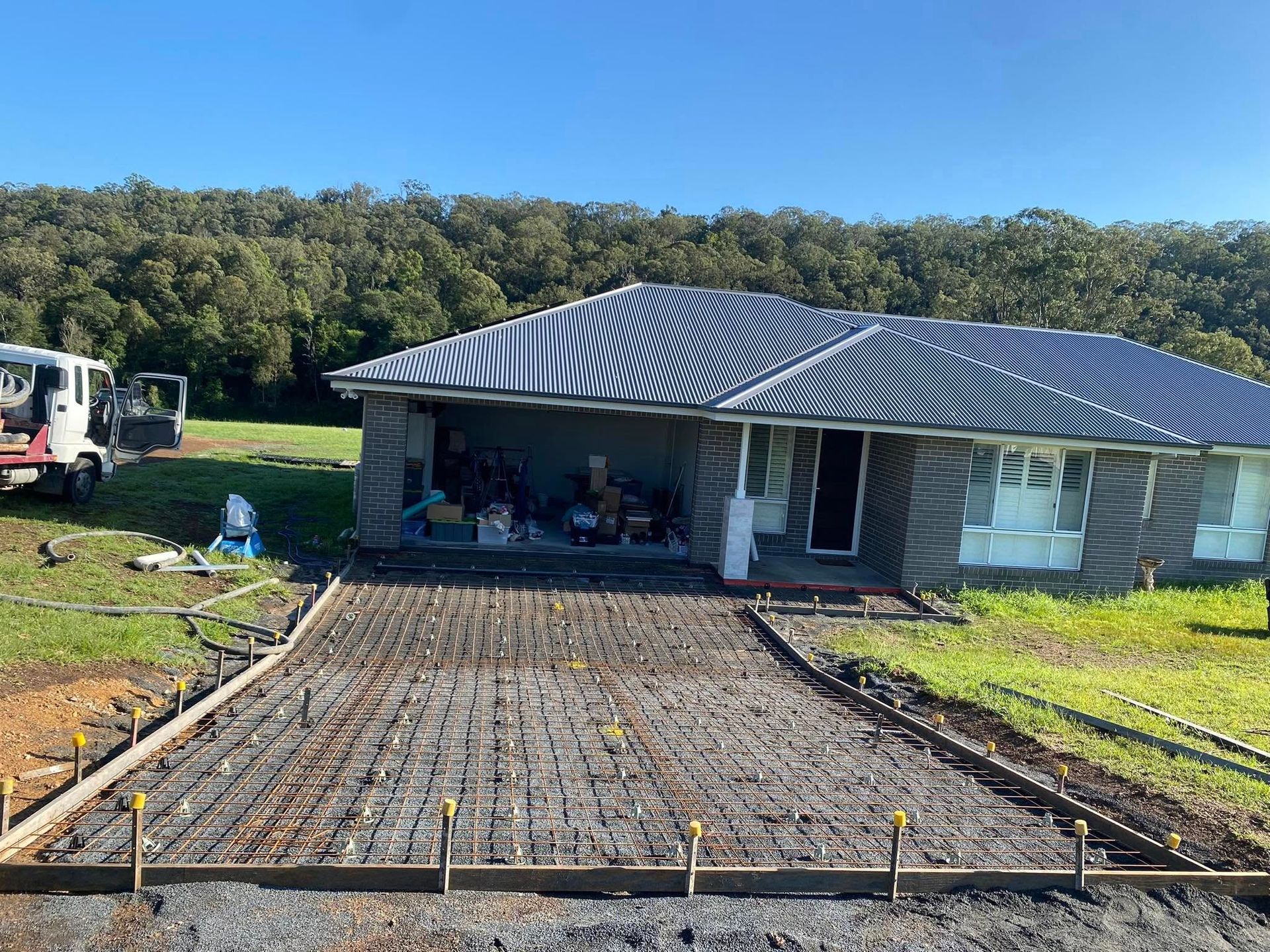 Concrete Driveway Under Construction in Front of a House — Rhyno’s Concreting In Old Bar, NSW