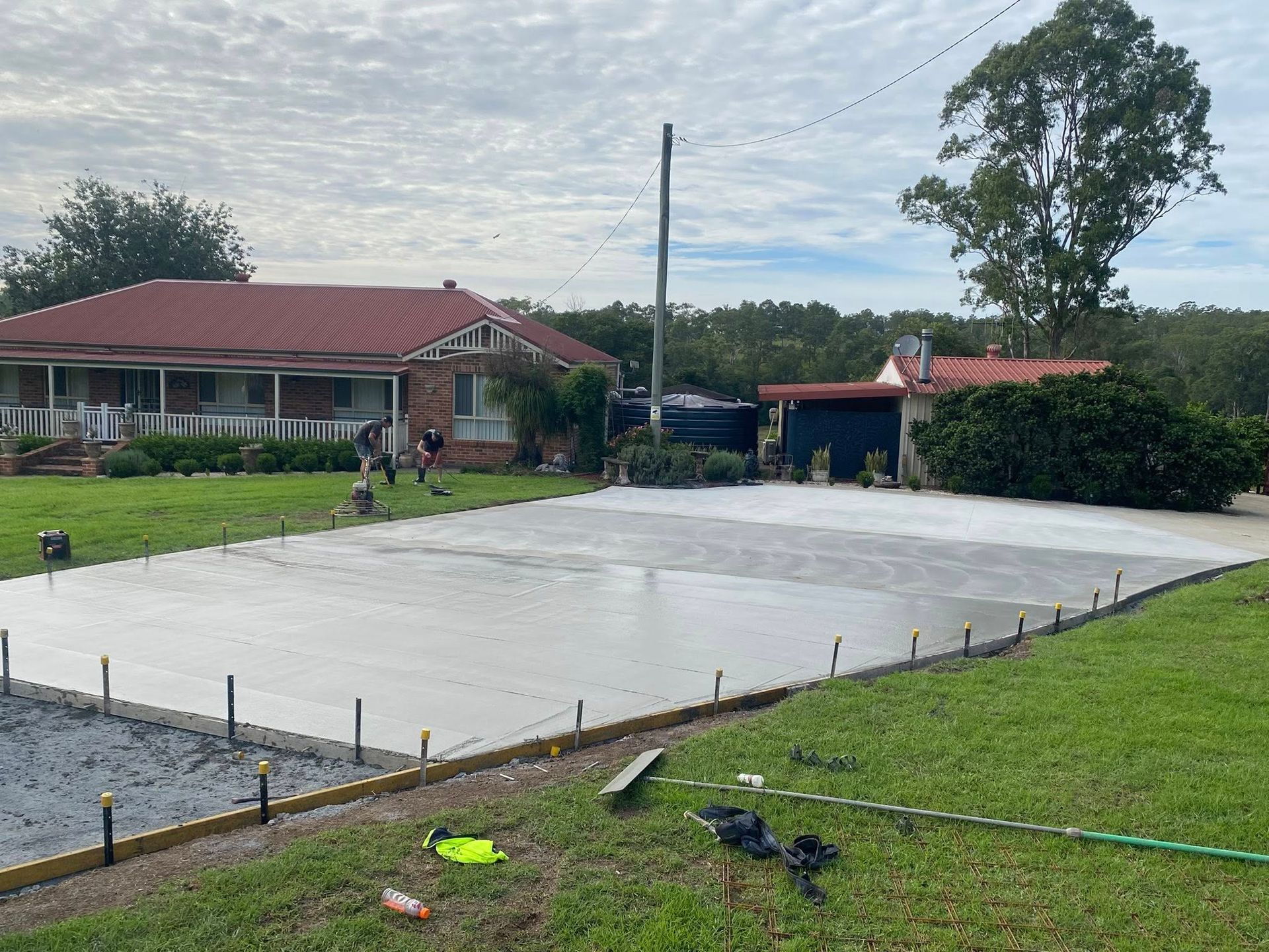 Newly Poured Concrete Driveway With Red/white Tape, in Front of a House — Rhyno’s Concreting In Old Bar, NSW