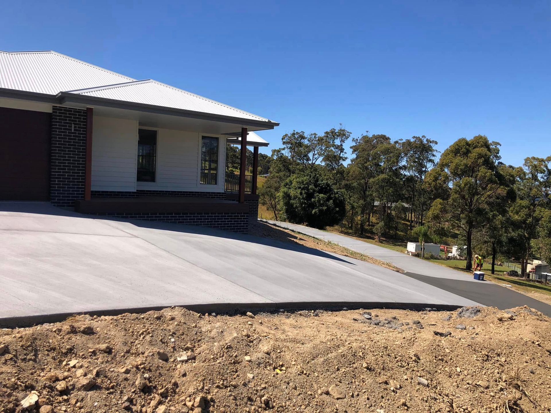 A House With a Concrete Driveway on a Sunny Day — Rhyno’s Concreting In Old Bar, NSW
