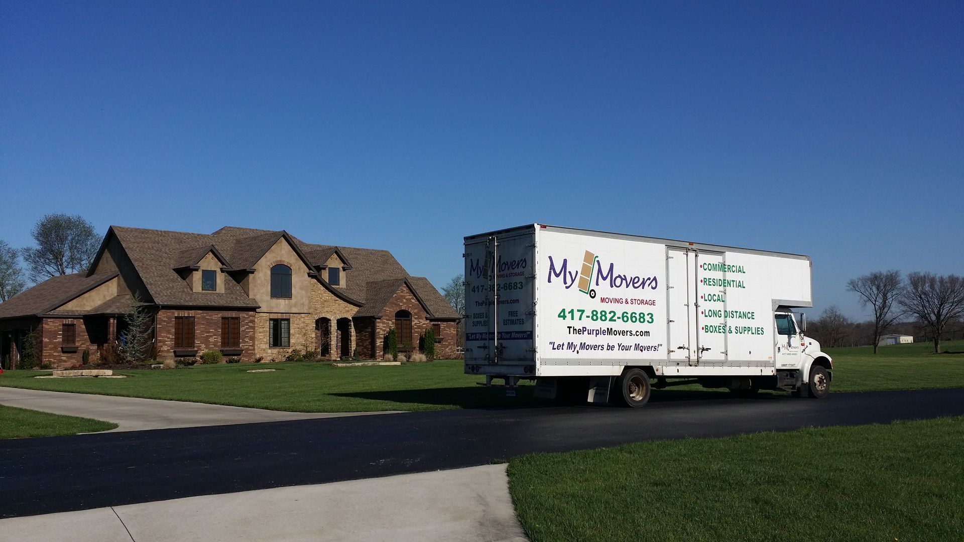 White Wheaton moving truck with ramp extended on a sunny day