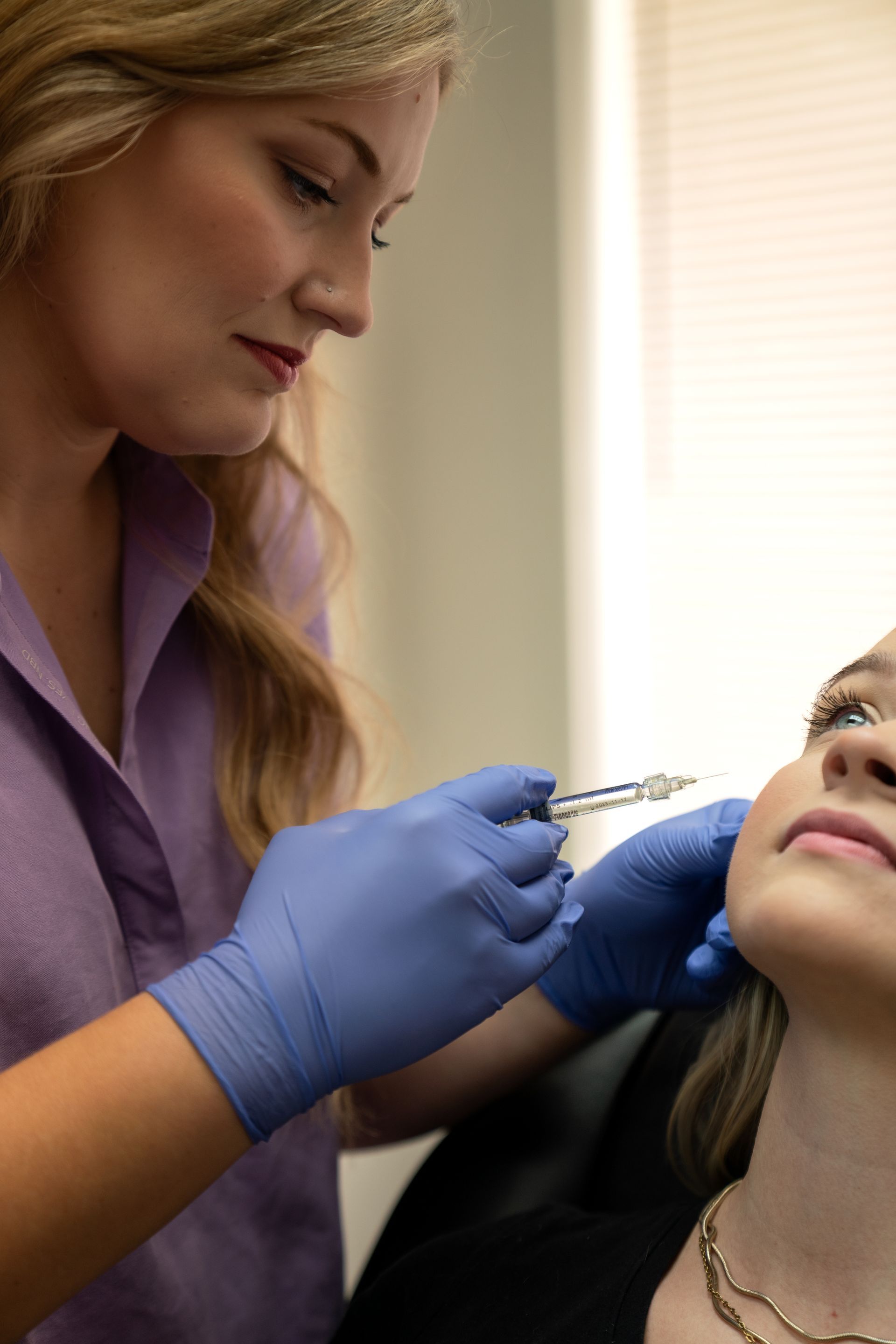 A woman is getting a botox injection in her face.