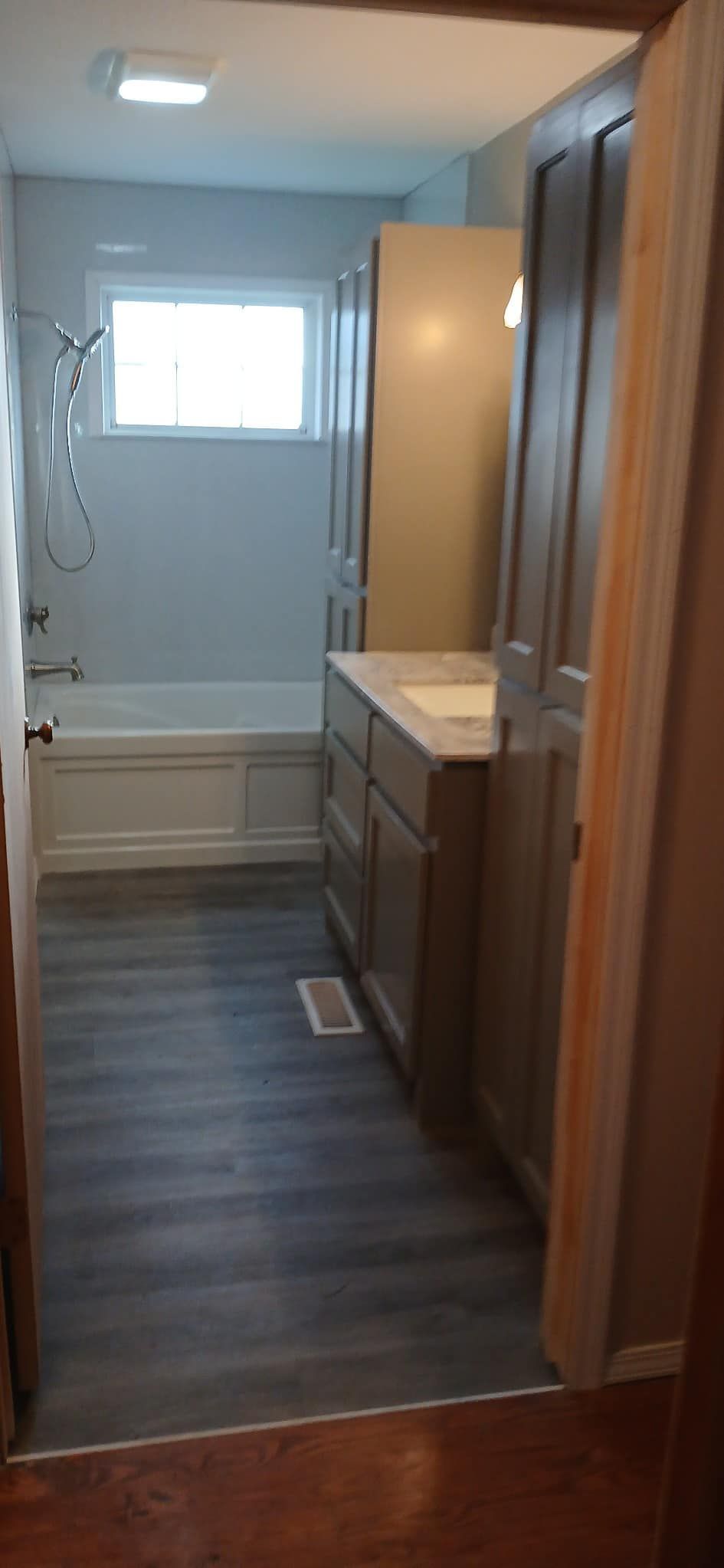 A bathroom with a sink , tub and shower.