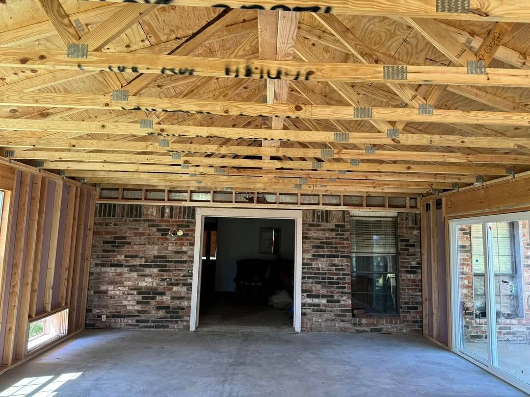 A large room with a brick wall and wooden beams.