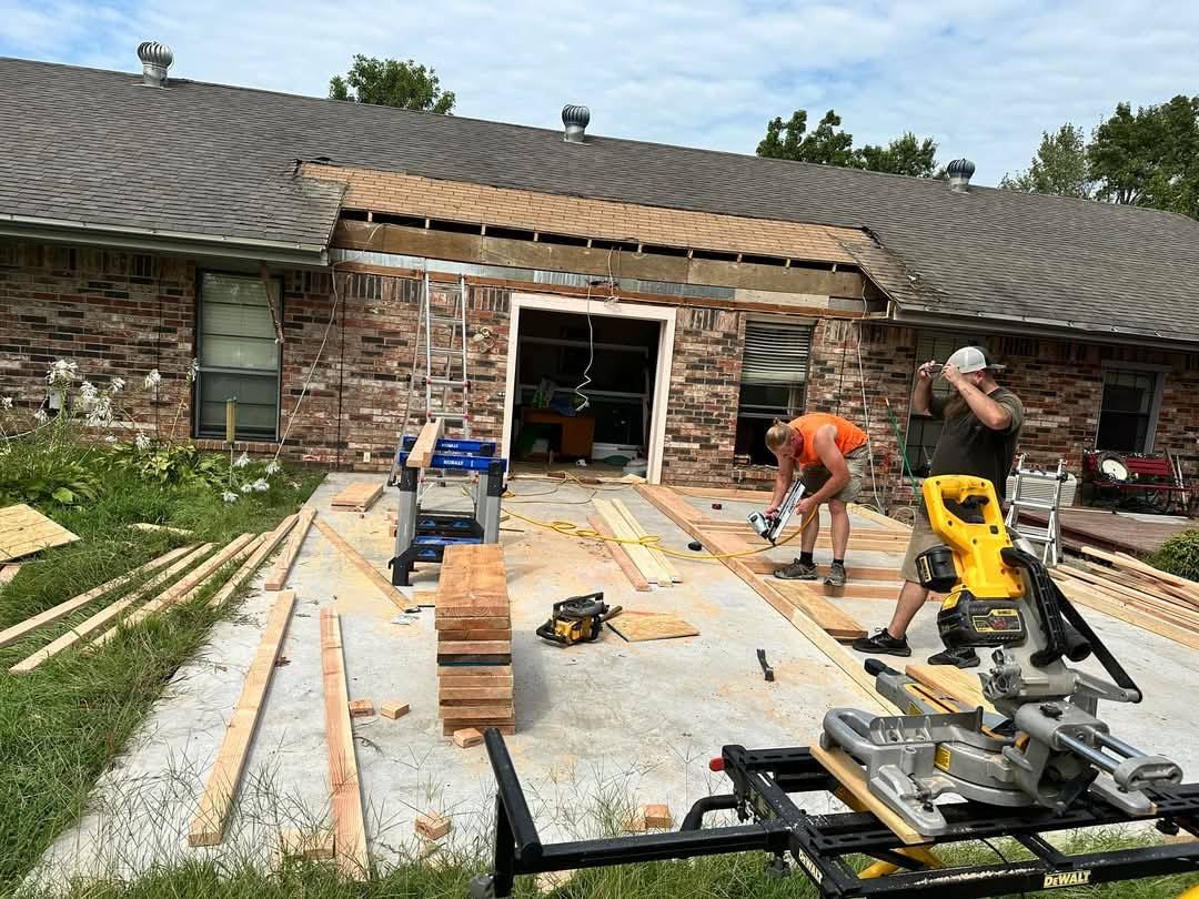 A group of men are working on the roof of a house.