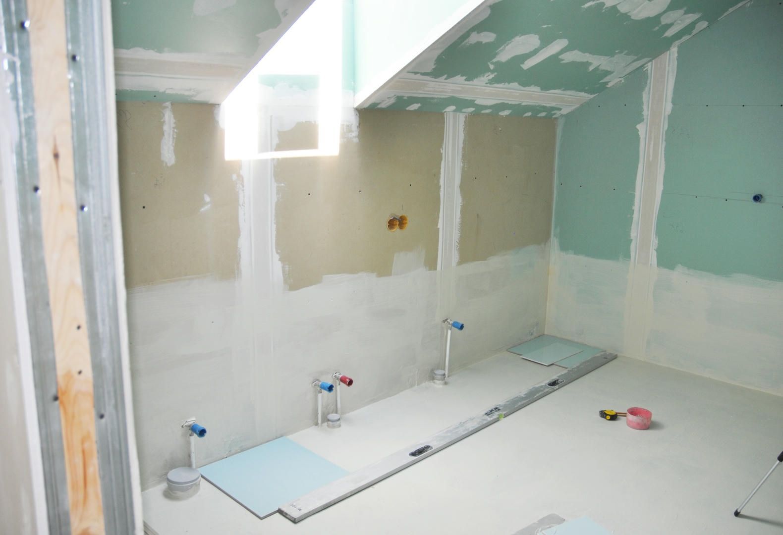A bathroom under construction with tiles on the floor.