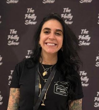 Smiling woman in a black shirt standing before a 