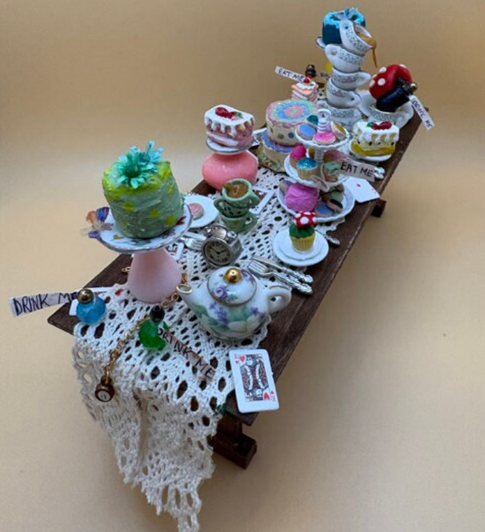 Decorative tea table with stacked cups, pastries, and colorful treats on a lace-covered tray