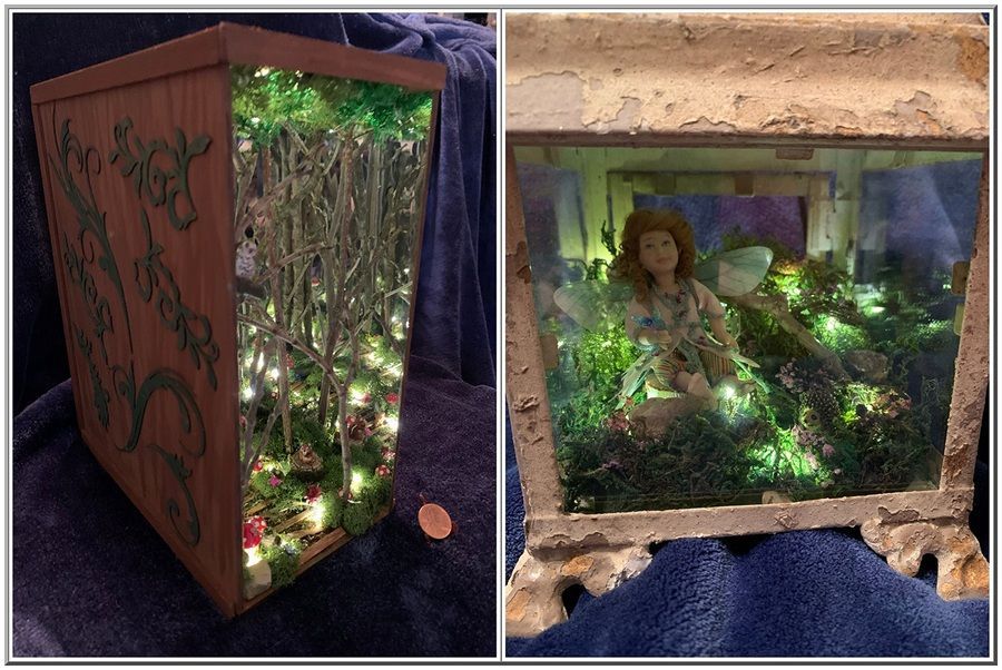 Miniature diorama in a wooden frame with a small ship finial, showing a figurine and stacked boxes inside.
