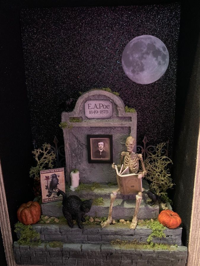 Halloween-style graveyard altar with a full moon, pumpkins, candles, and a black cat on stone steps