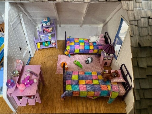 Miniature Victorian dollhouse scenes with figures, horses, and a small storefront interior