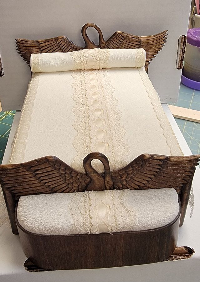 Wicker basket with cream cushioned insert and brown woven trim on a table