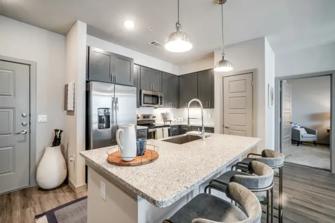 Modern open-concept living space with floors, neutral tones at  One90 Firewheel in Garland,TX.