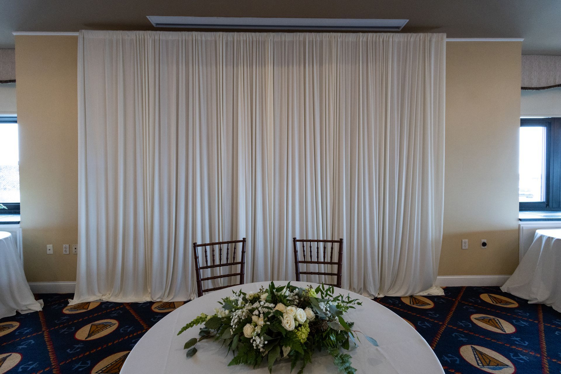 Harvard Boat Club room with Lit Tables, uplighting, Pipe and Drape chairs and a dj booth with Fiber Optic Backdrop and LED 65