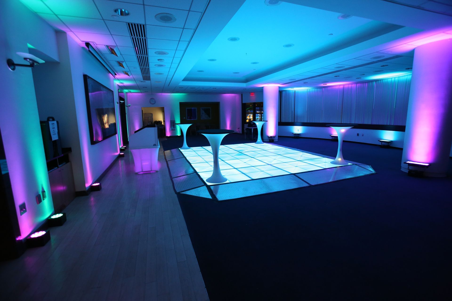A large room with a dance floor and a dj set up