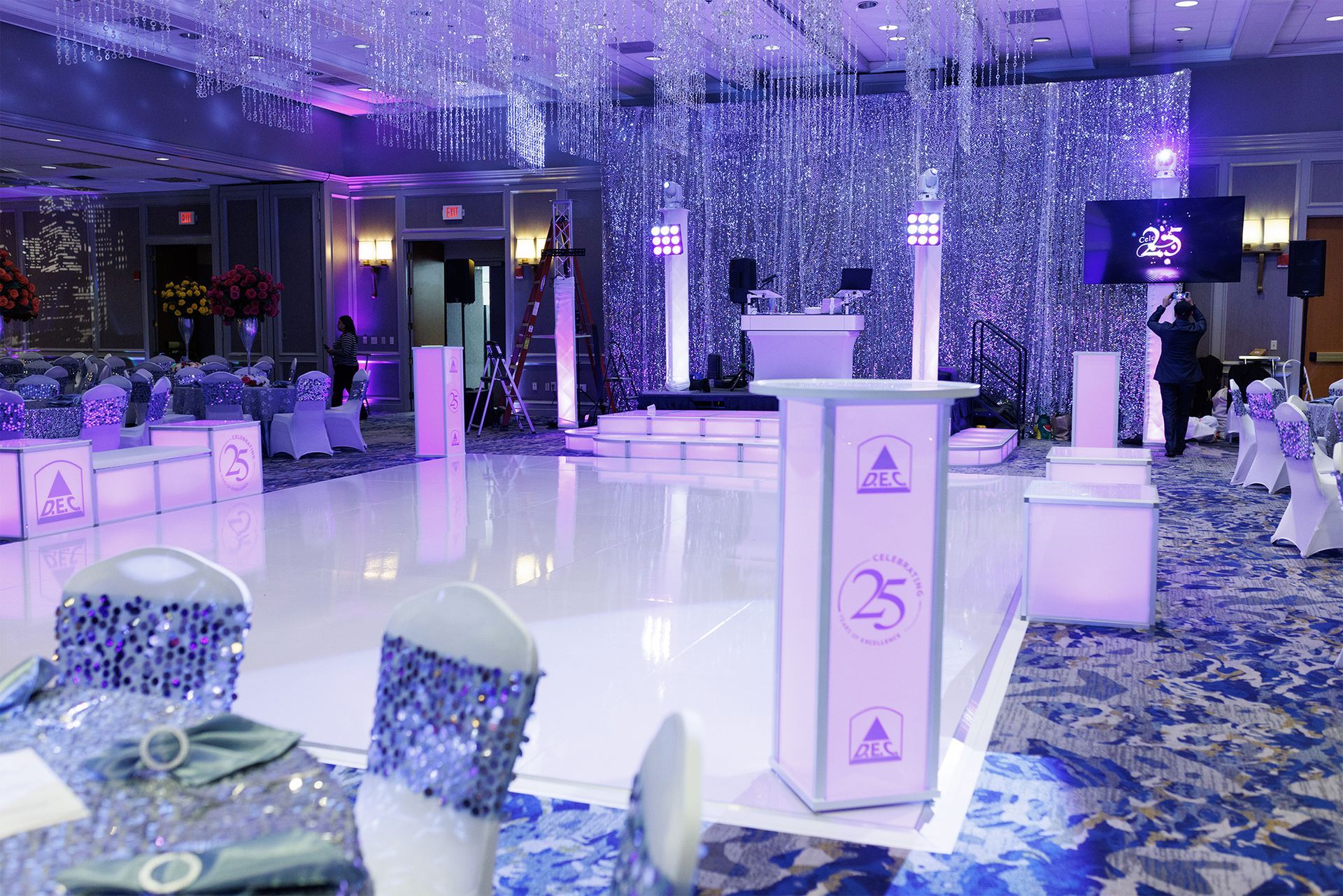 A large group of people are dancing at a wedding reception.