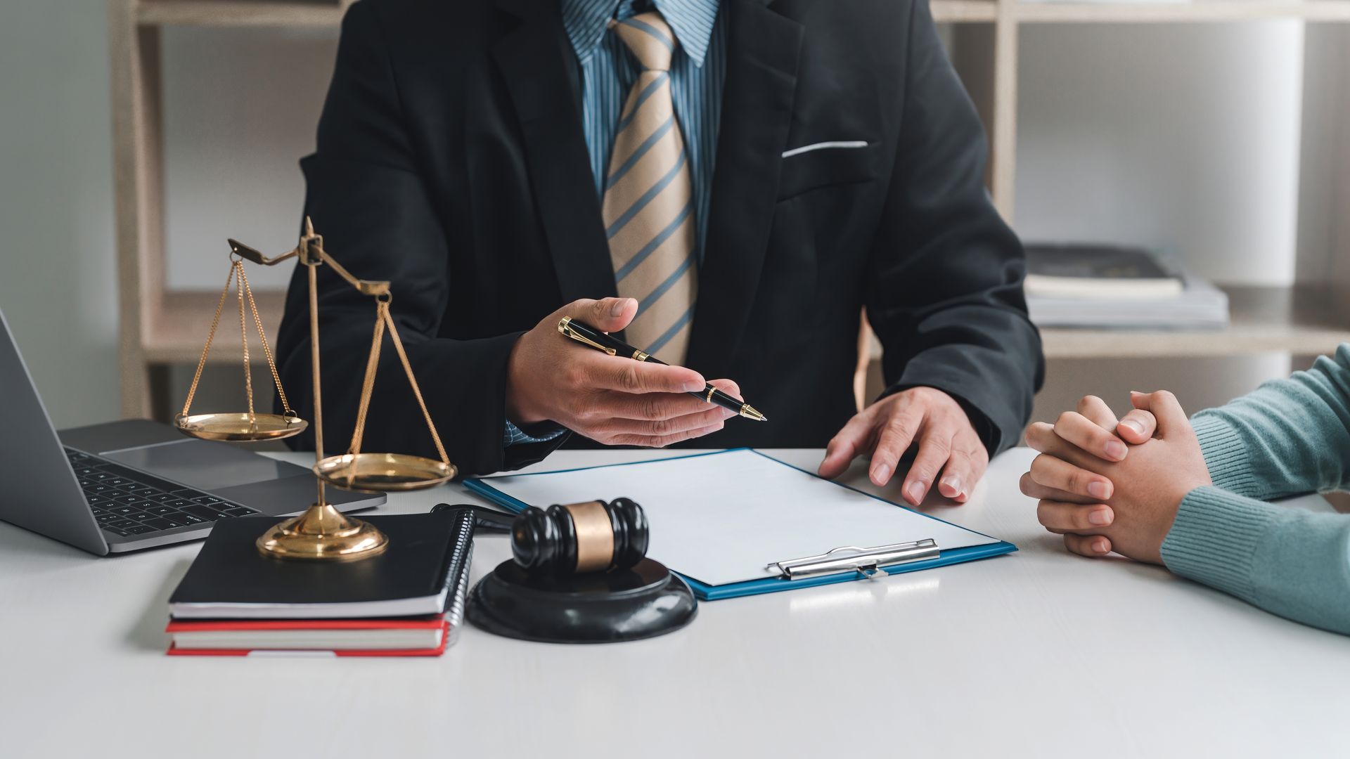 A lawyer is sitting at a desk talking to a client.