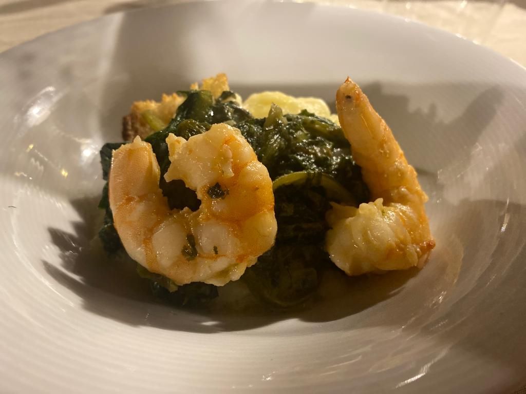 Gamberi e verdure in una ciotola bianca, serviti con una salsa leggera.