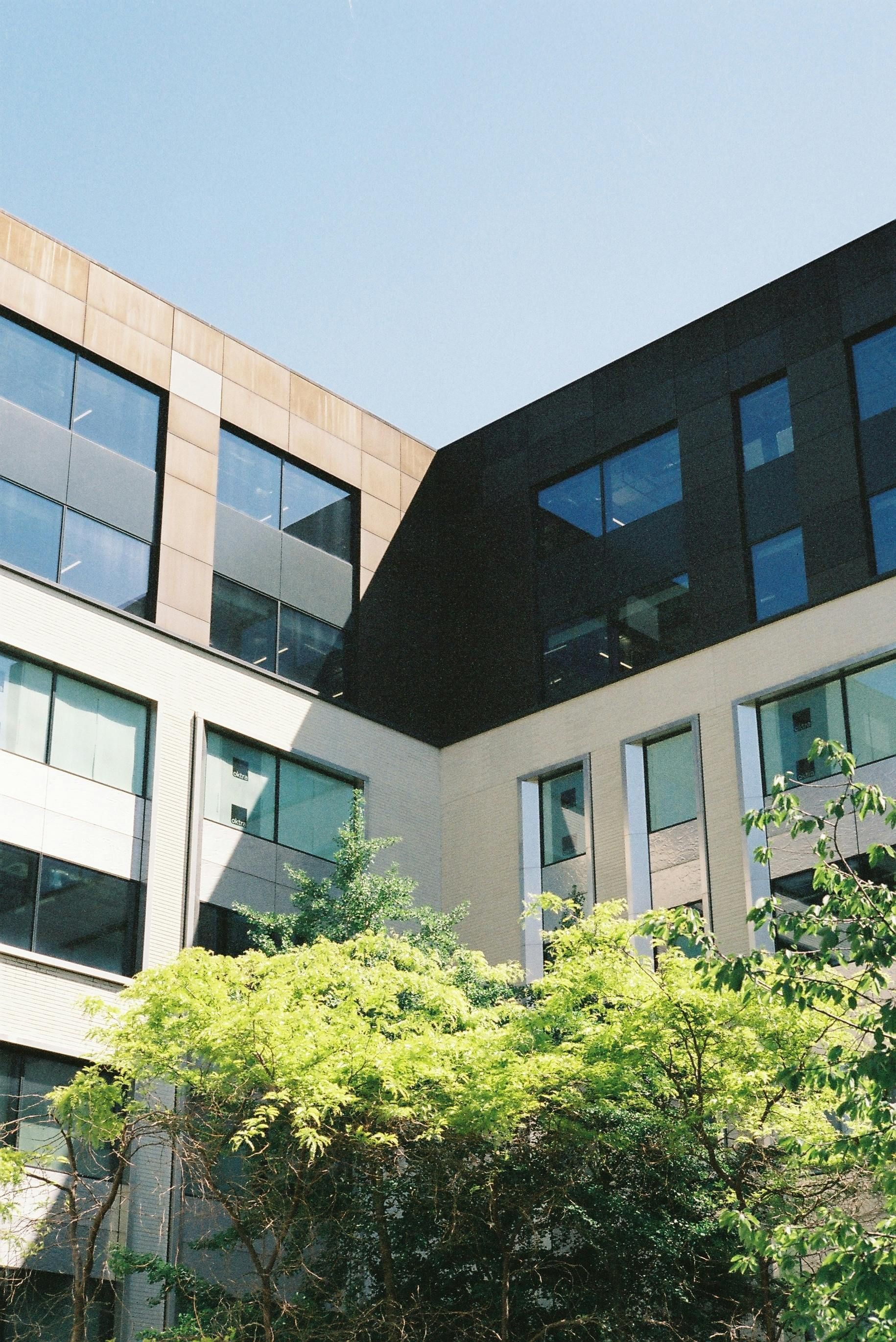 A large building with lots of windows and trees in front of it