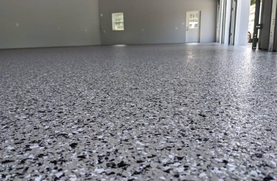Empty speckled epoxy floor in a large industrial room.