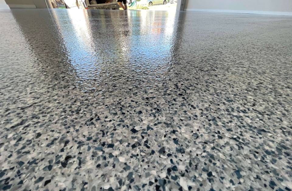 Polished speckled gray floor with bright reflections in the distance