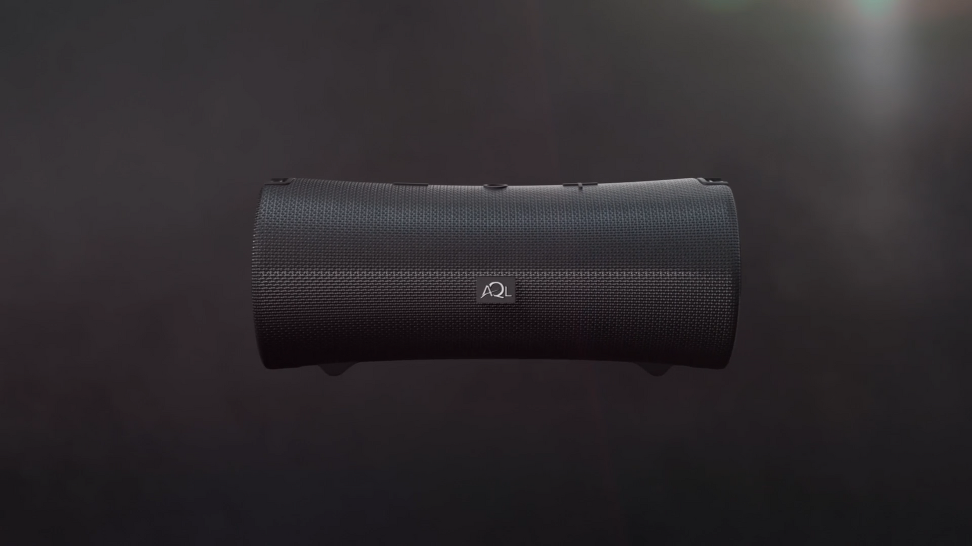Black, cylindrical audio speaker with a silver logo, set against a dark background.