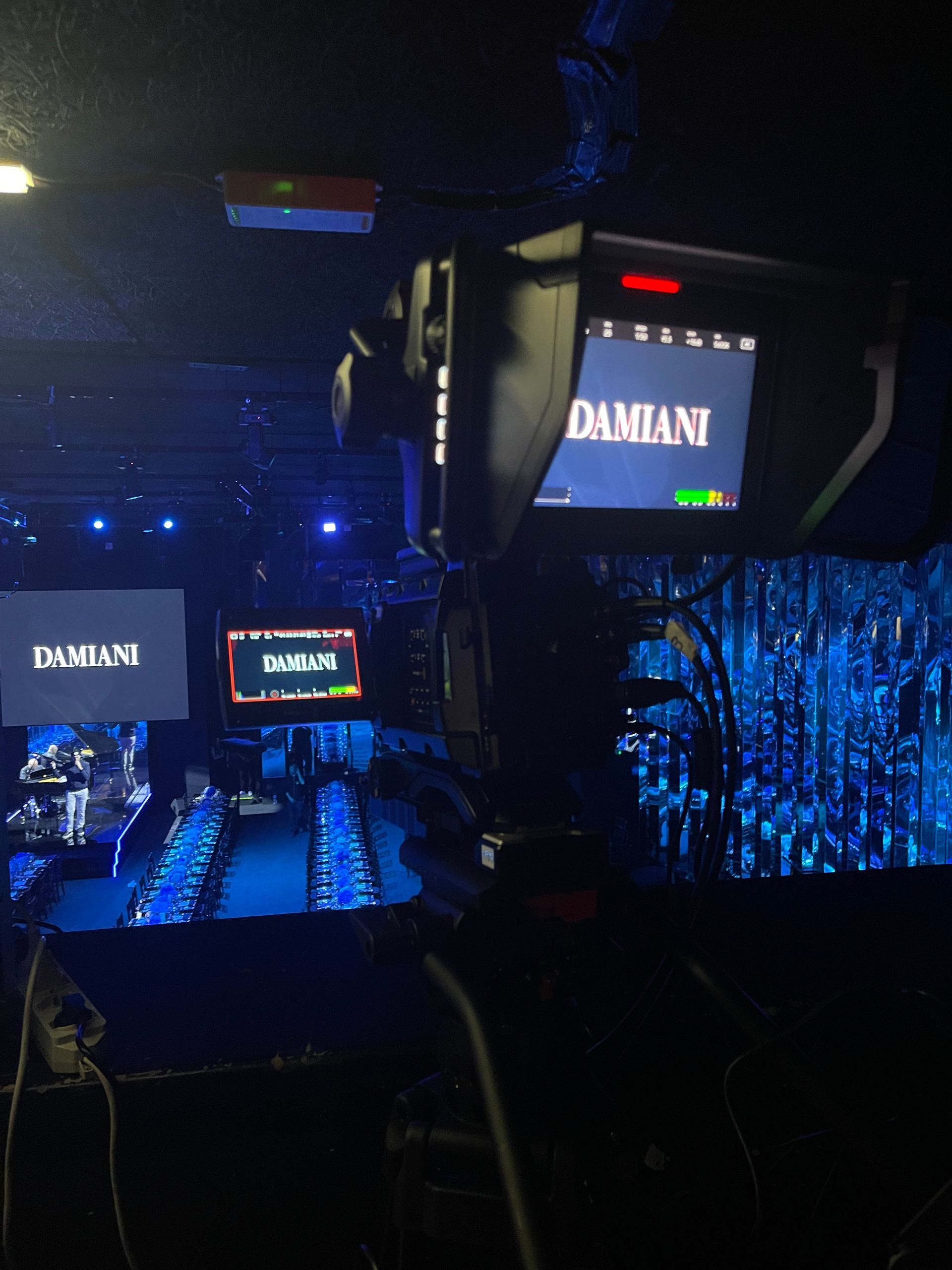 A professional video camera filming a fashion show runway with the