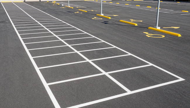 Fresh parking lot striping with bright white lines on black asphalt in Dallas, TX
