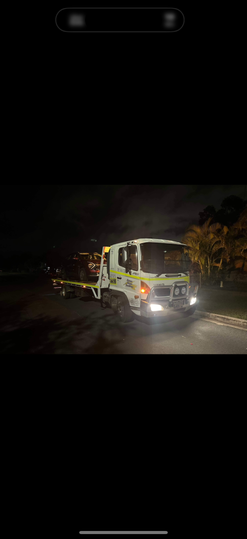 Tow truck on a dark road with headlights on.— Fitzroy Towing & Transport in Parkhurst, QLD