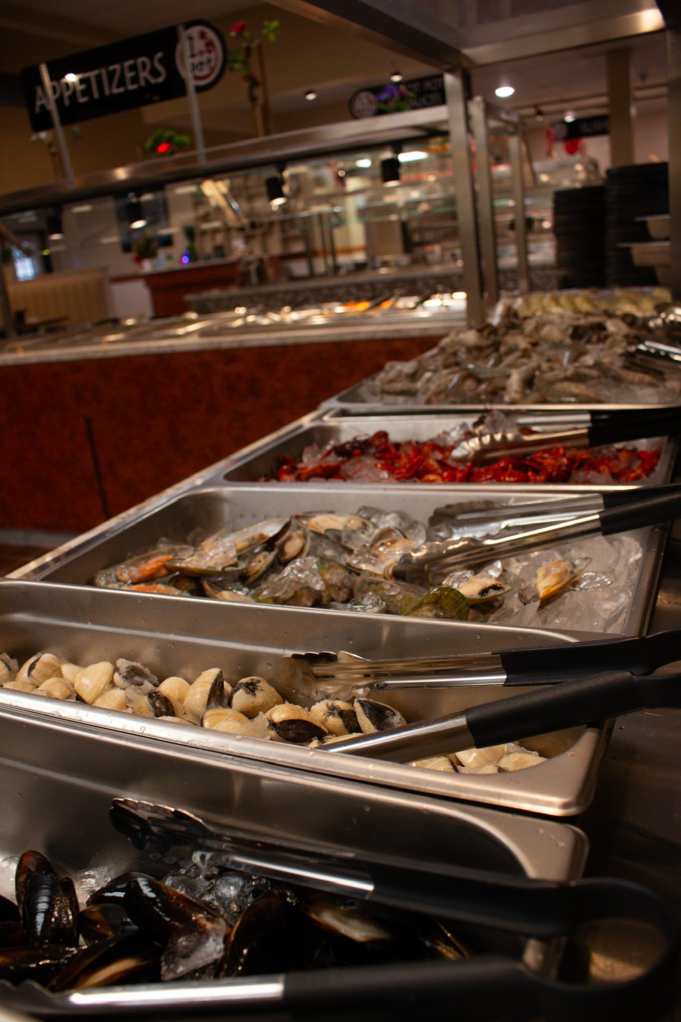 Seafood buffet trays with shrimp, clams, and mussels in a restaurant