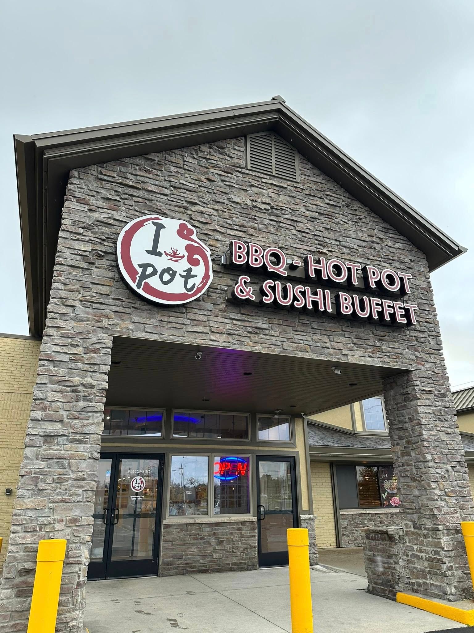 Restaurant storefront with stone facade, circular logo, and sign reading “Big Horns & Sushi Fusion”