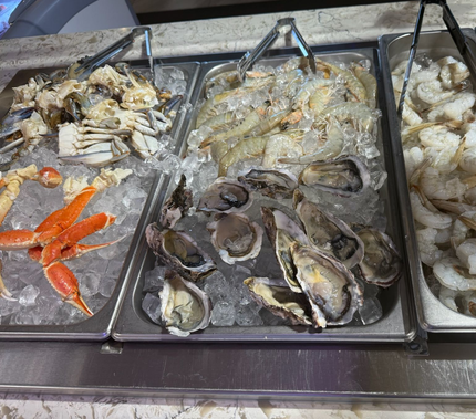 Seafood market display with crabs, oysters, shrimp, and shellfish on ice trays
