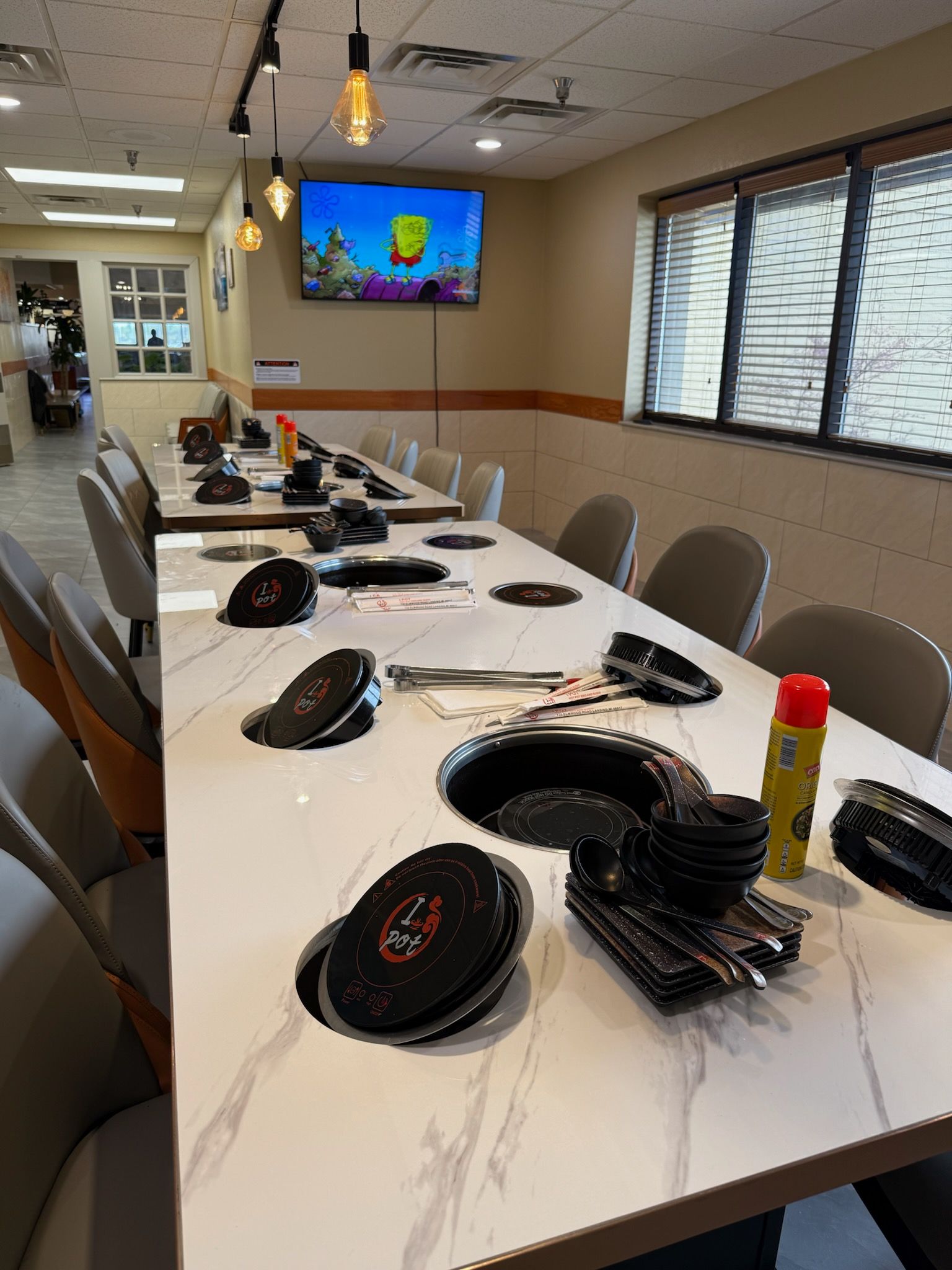 Conference room with a long white table, headsets, monitors, and a wall-mounted TV.