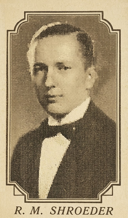 Sepia portrait of R. M. Schroeder in a suit and bow tie, with decorative border.