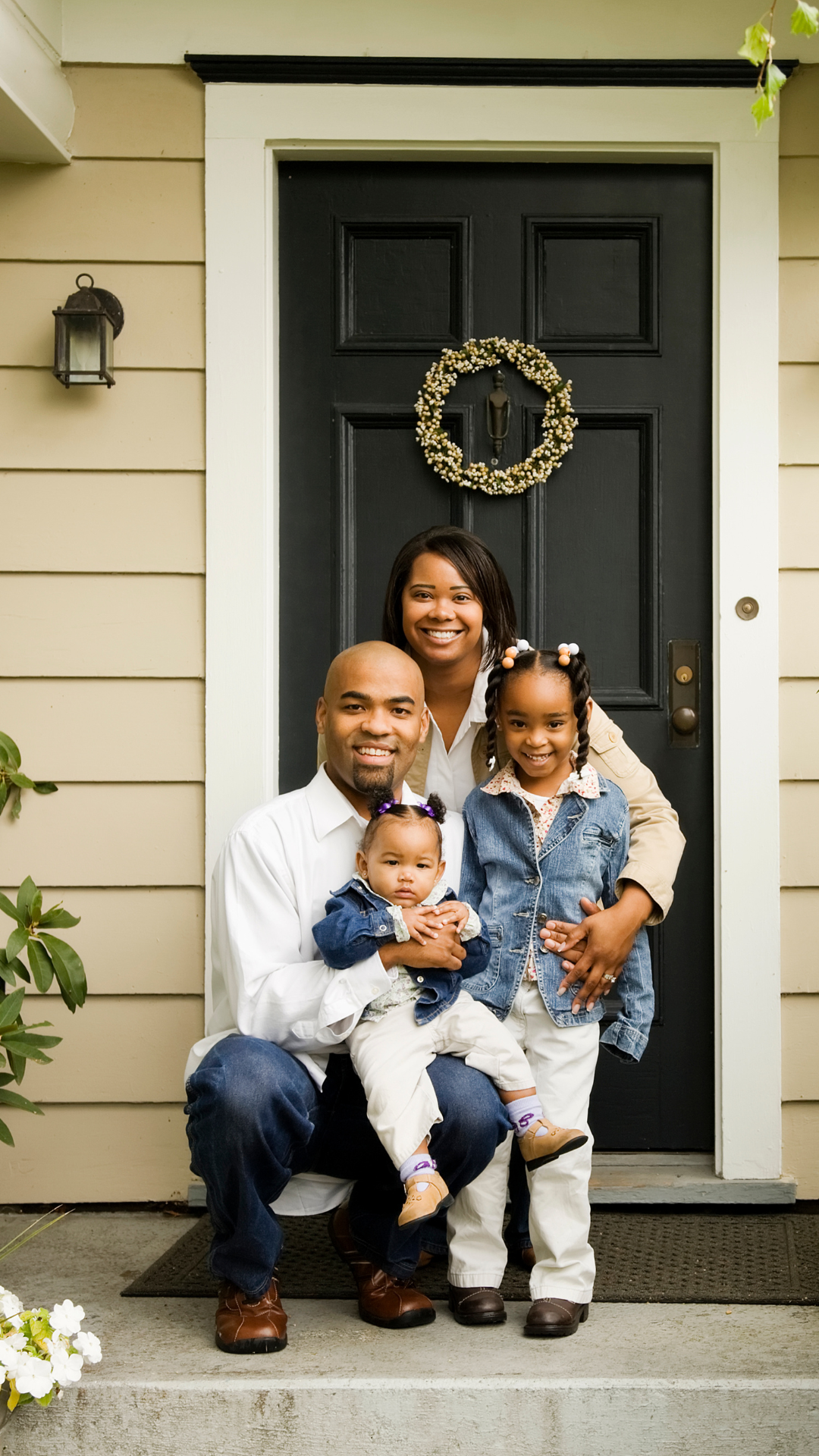 A family is posing for a picture in front of their house