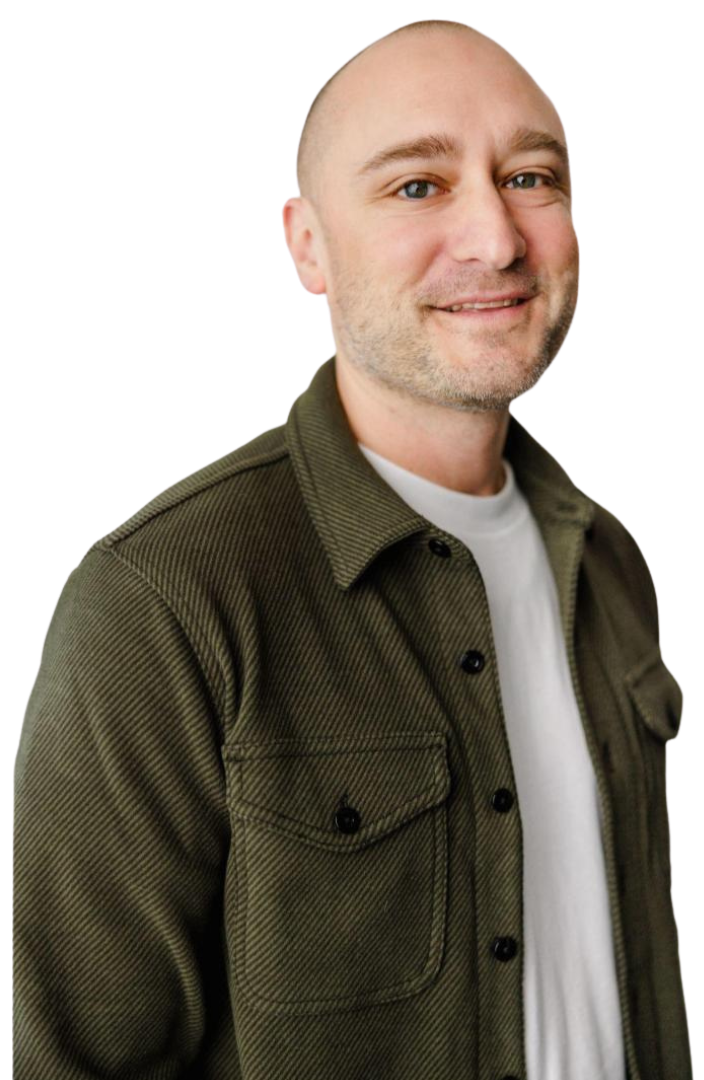 D.Rowe wearing a green jacket and a white shirt is smiling.