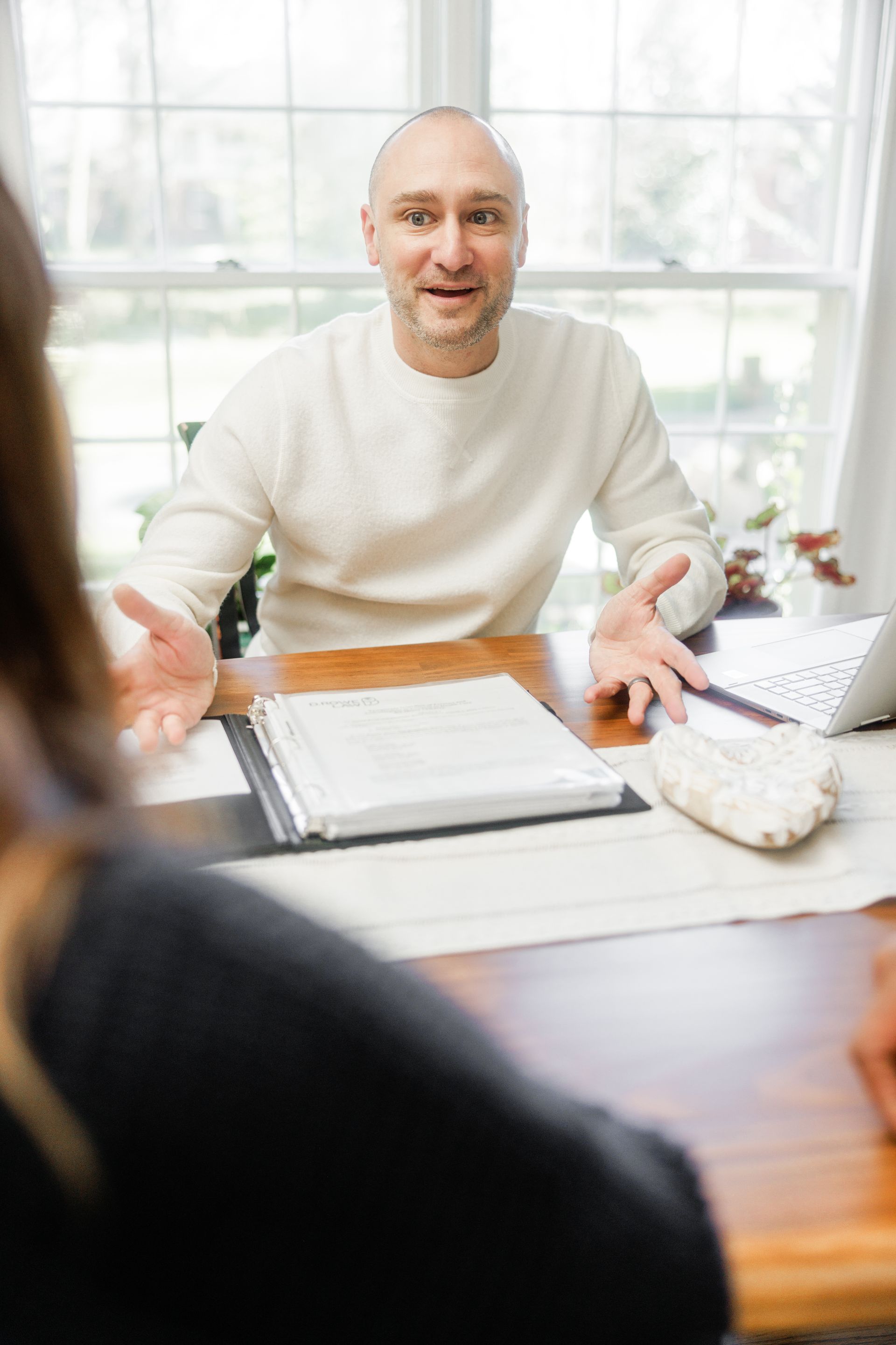 A man is sitting at a desk talking to a woman.