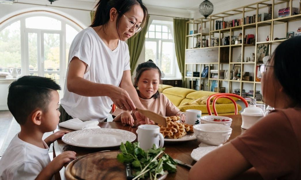 A family is sitting at a table eating food.