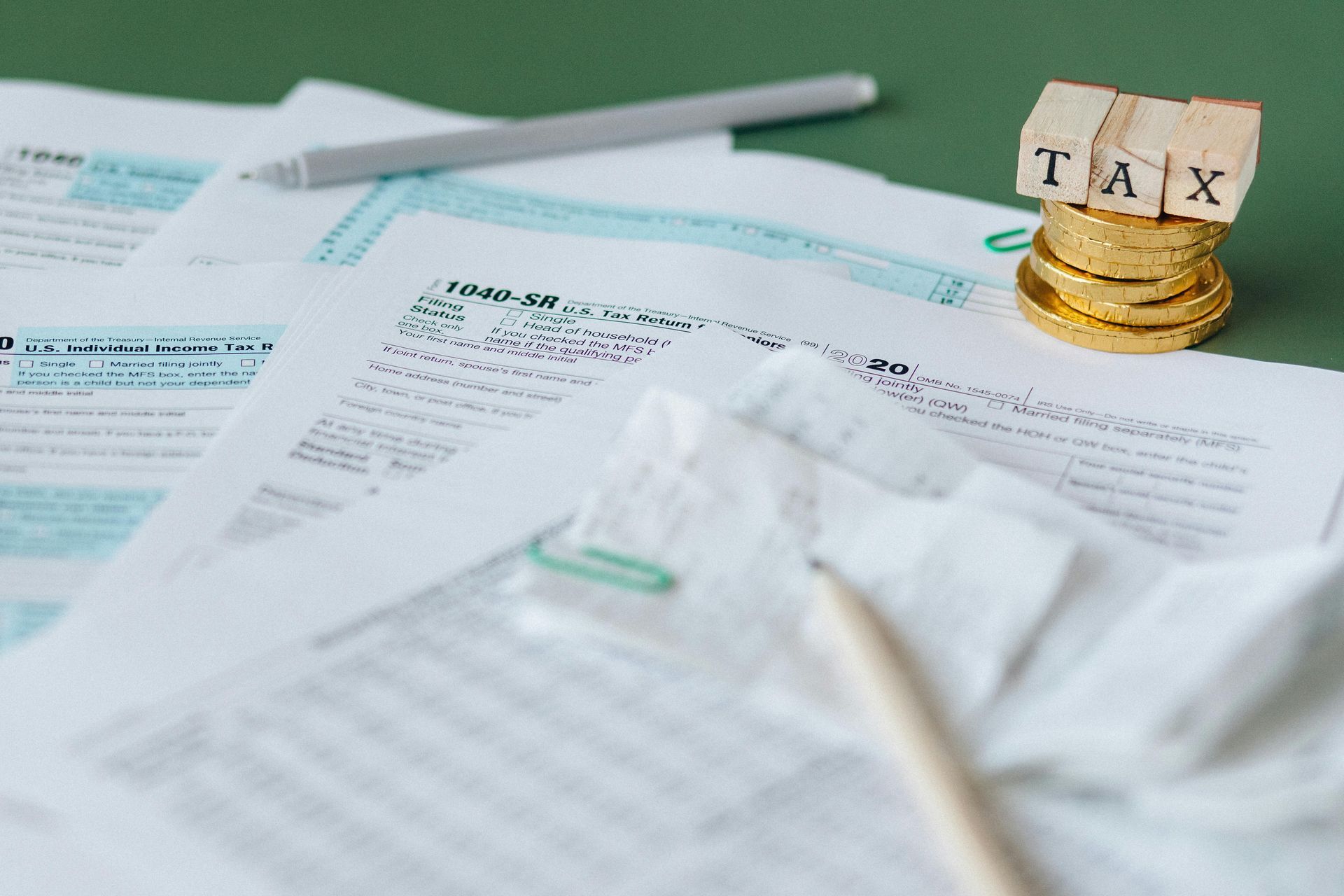 A stack of coins sitting on top of a piece of paper with the word tax written on it.