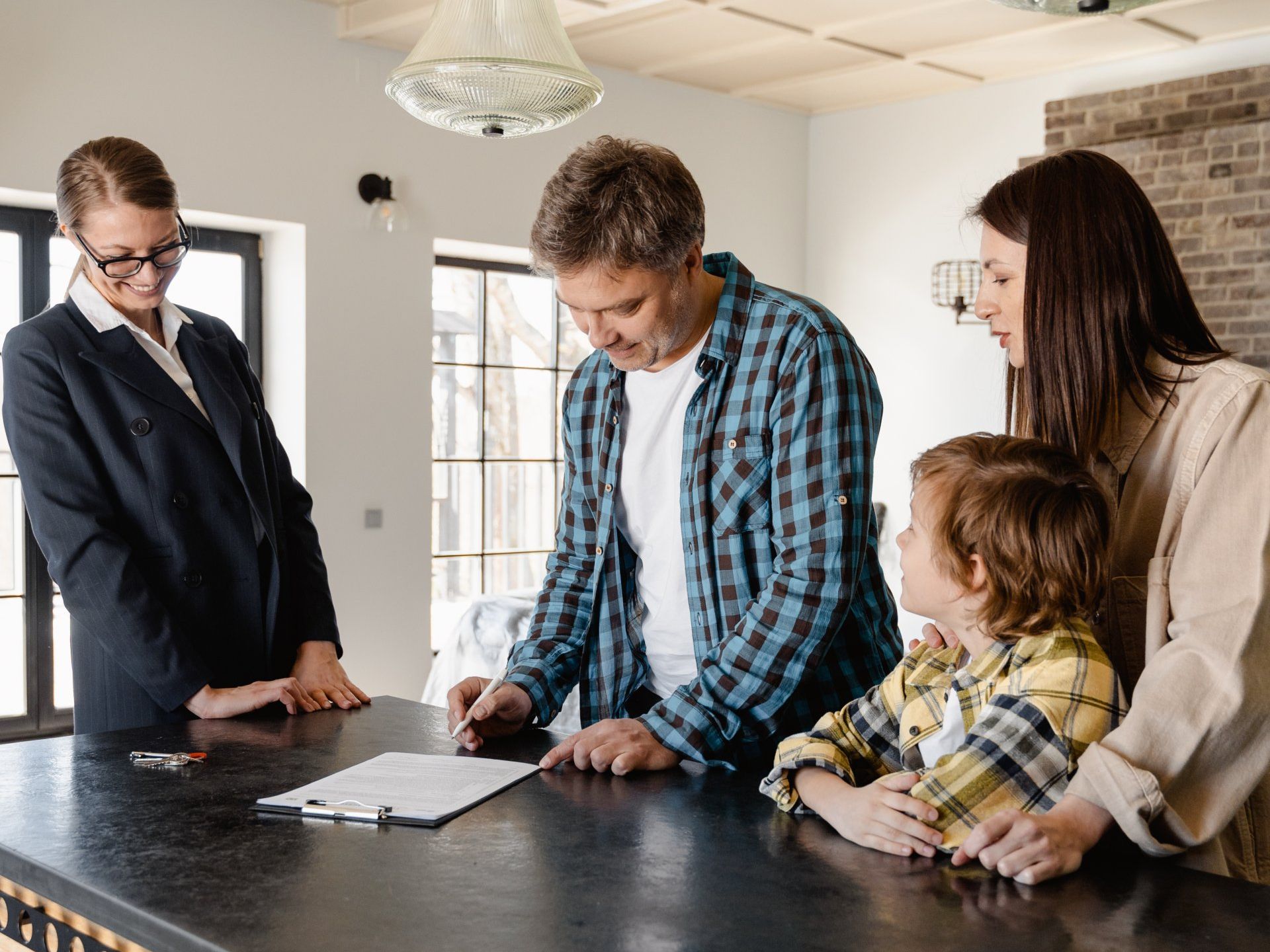 A family is sitting at a table with a real estate agent.