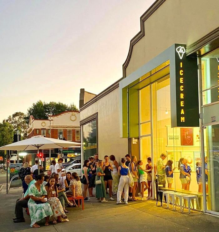 A Group of People Standing Outside of a Building — We Design & Manufacture Signage in the Albury-Wodonga, NSW