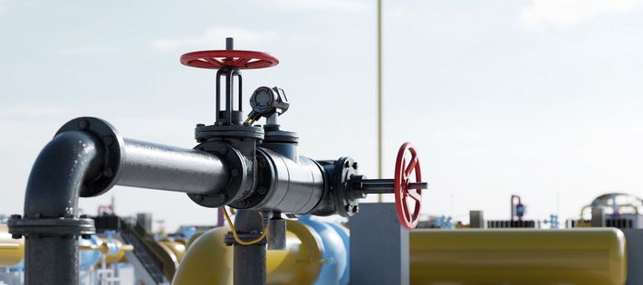 A close up of a gas pipe with a red valve on it.