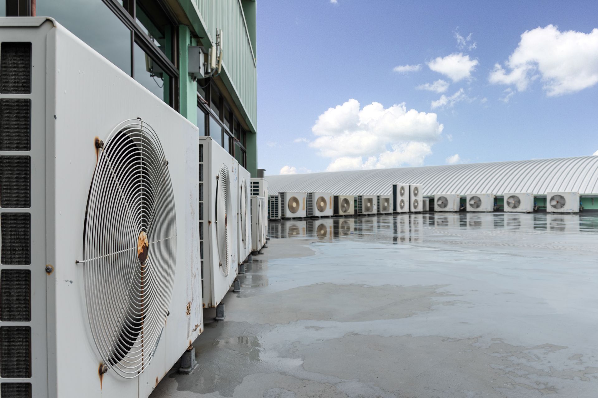 A row of air conditioners on the side of a building. Heat pump installation in Gresham OR